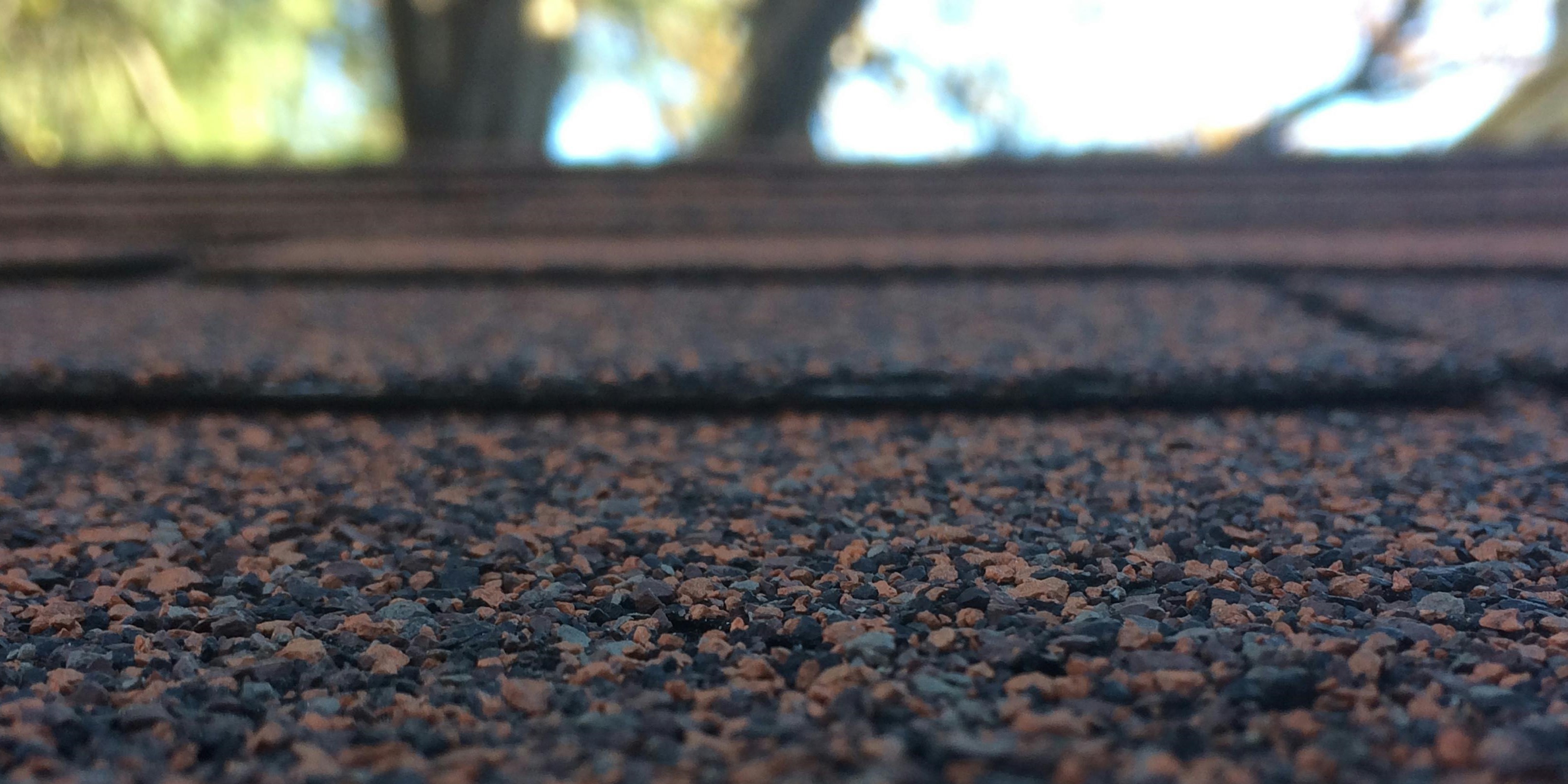 Close-up of asphalt shingles on a residential roof, showcasing their affordability and versatility.